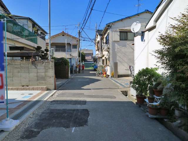 狭い街路沿いに一戸建てが並んでいます。
