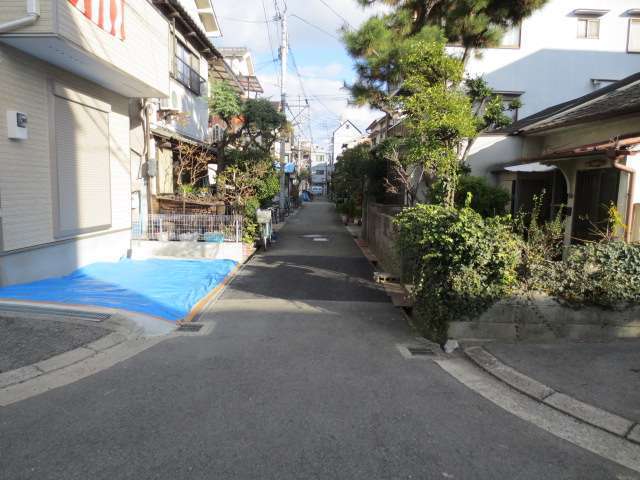 町の南部を西側から見た景色。細い路地沿いの住宅地ですが、生垣や植栽のある家が見られます。