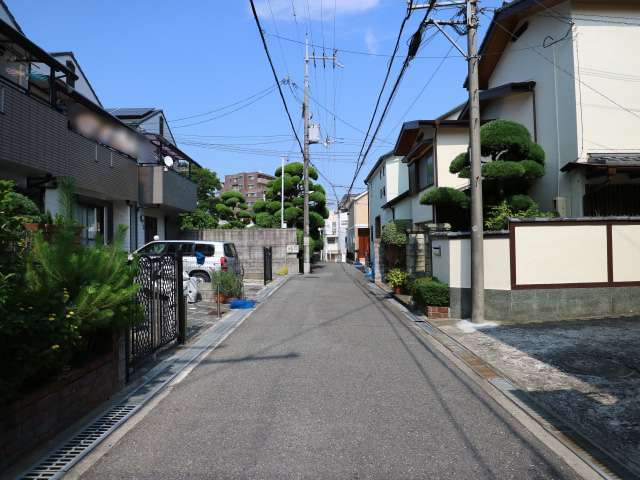 町の北部を東方向から見た景色。生垣や植栽のある一戸建てが並んでいます。