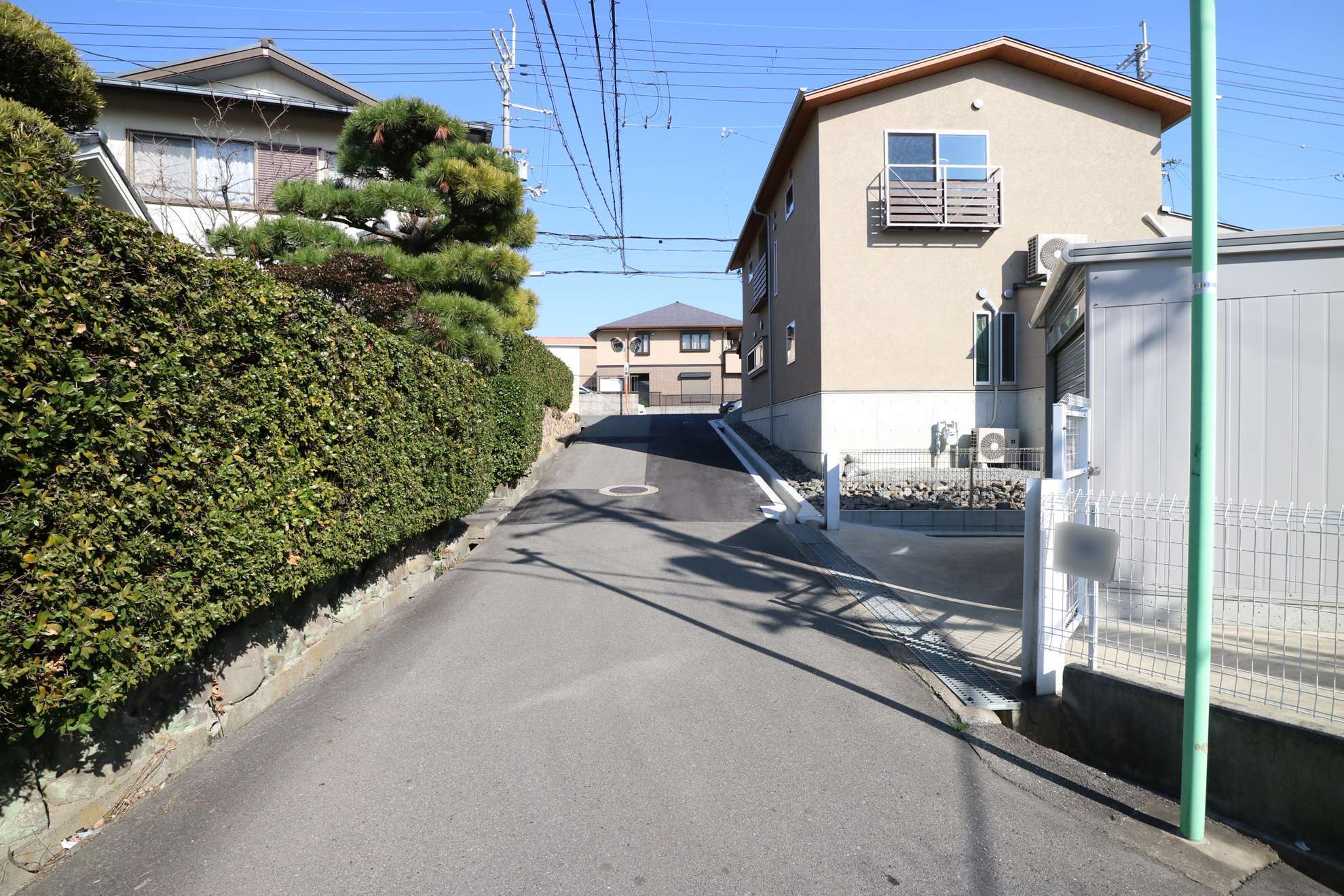 町の南東部を西方向から見た景色。道幅の狭い街路沿いに一戸建てが並んでいます。