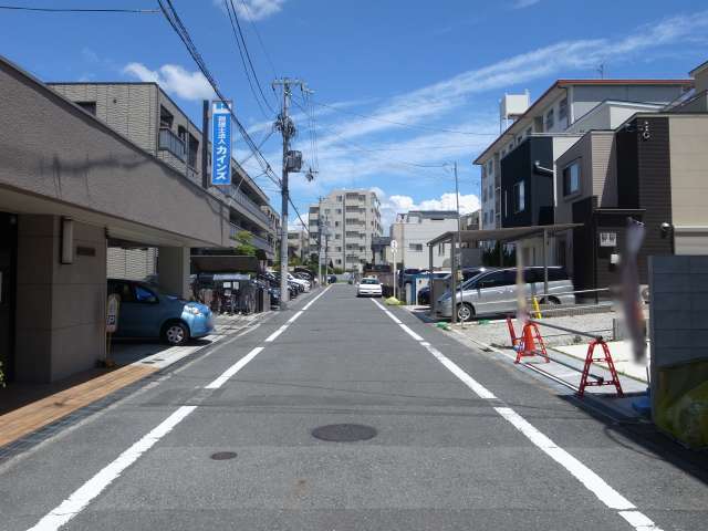 間tの西部を西方向から見た景色。直線的な道路沿いに一戸建てやマンションが並んでいます。