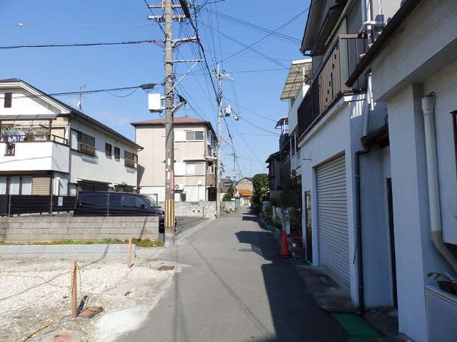町の南東部を南方向から見た景色。狭い道路沿いに一戸建てやアパートなどが並んでいます。