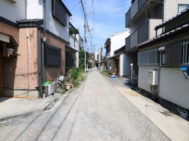 未舗装の狭い街路沿いに一戸建てが並んでいます。