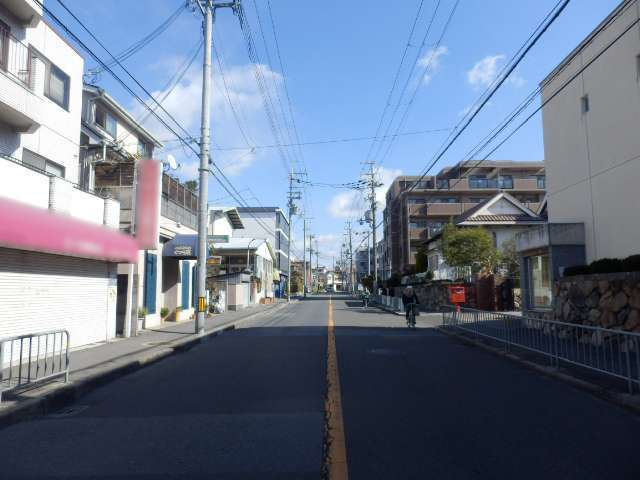 町の南端を走る主要道路を南西方向から見た景色。マンションや一戸建て、店舗などが並んでいます。