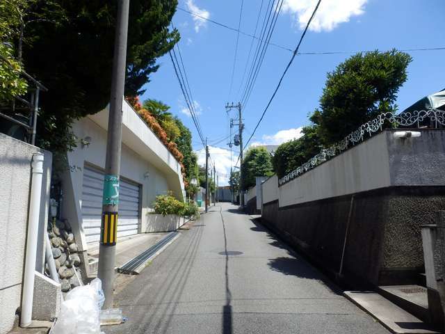 町の南西部を北西方向から見た景色。勾配が急な坂道沿いに敷地の広い一戸建てが並んでいます。