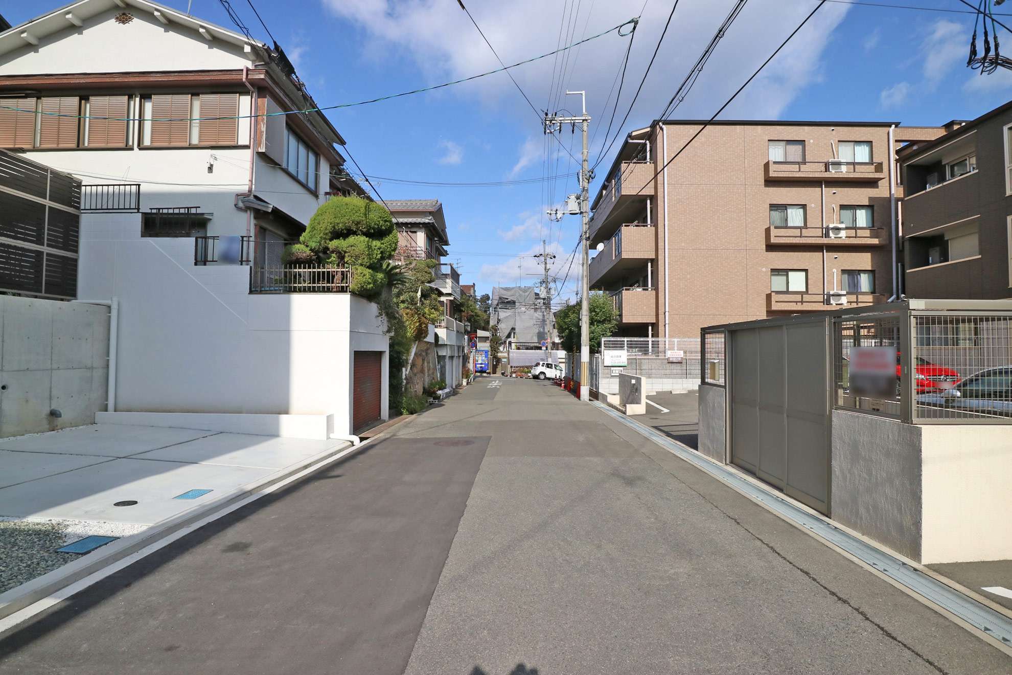 町の中央部を南方向から見た景色。一戸建てとマンションなどが混在しています。