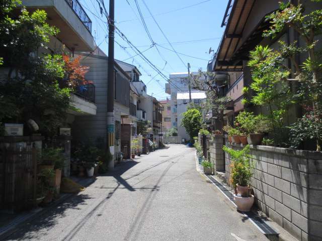 町の南部を東方向から見た景色。道幅の狭い道路沿いに一戸建てやマンションが建っています。