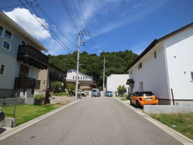 町の北東部を西方向から見た景色。住宅地の奥に山林が広がっています。