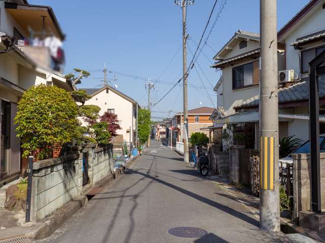 町の中央部を西方向から見た景色。道幅の狭い街路沿いに一戸建てが並んでいます。