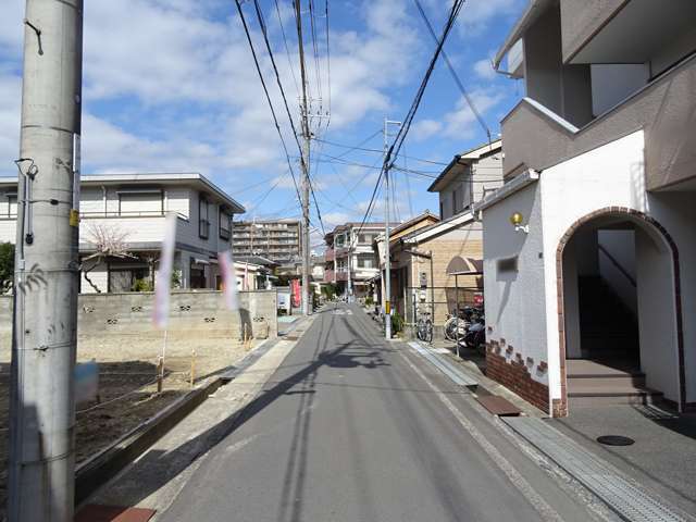町の中心部を南方向から見た景色。一戸建てやマンションなどが混在しています。