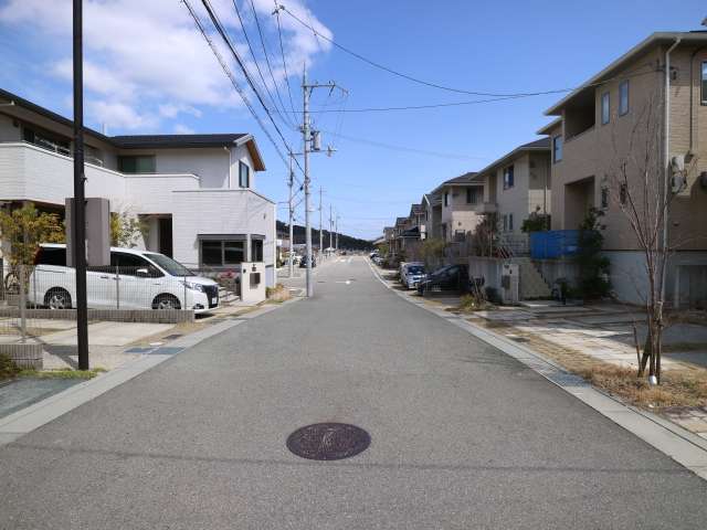 道幅の広い街路沿いに一戸建てが並んでいます。