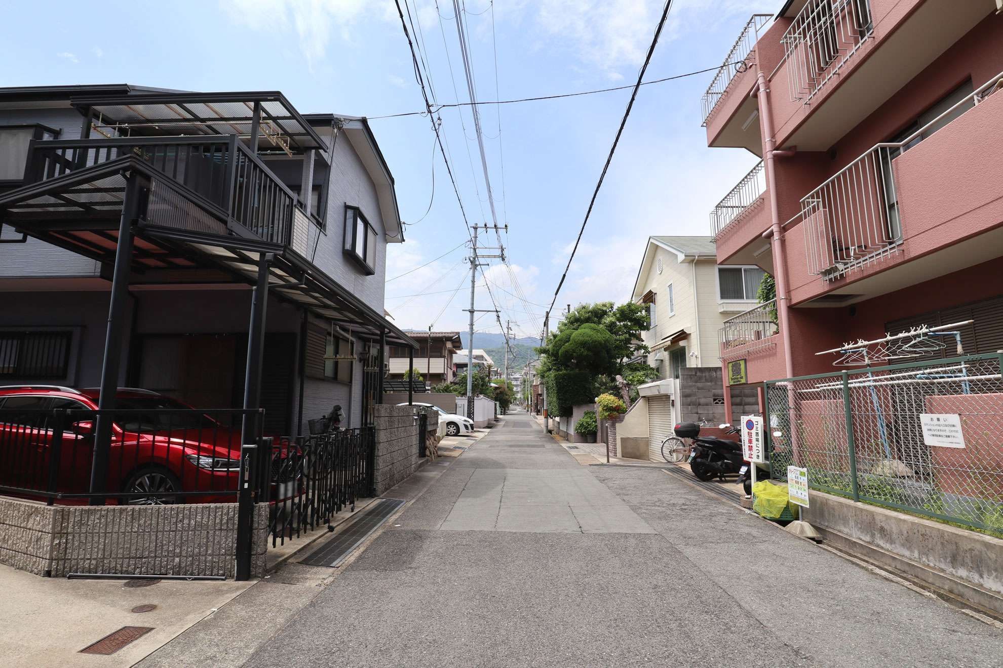 道幅はやや狭いながら、すっきりした印象の街並み。一戸建てやマンションなどが混在しています。