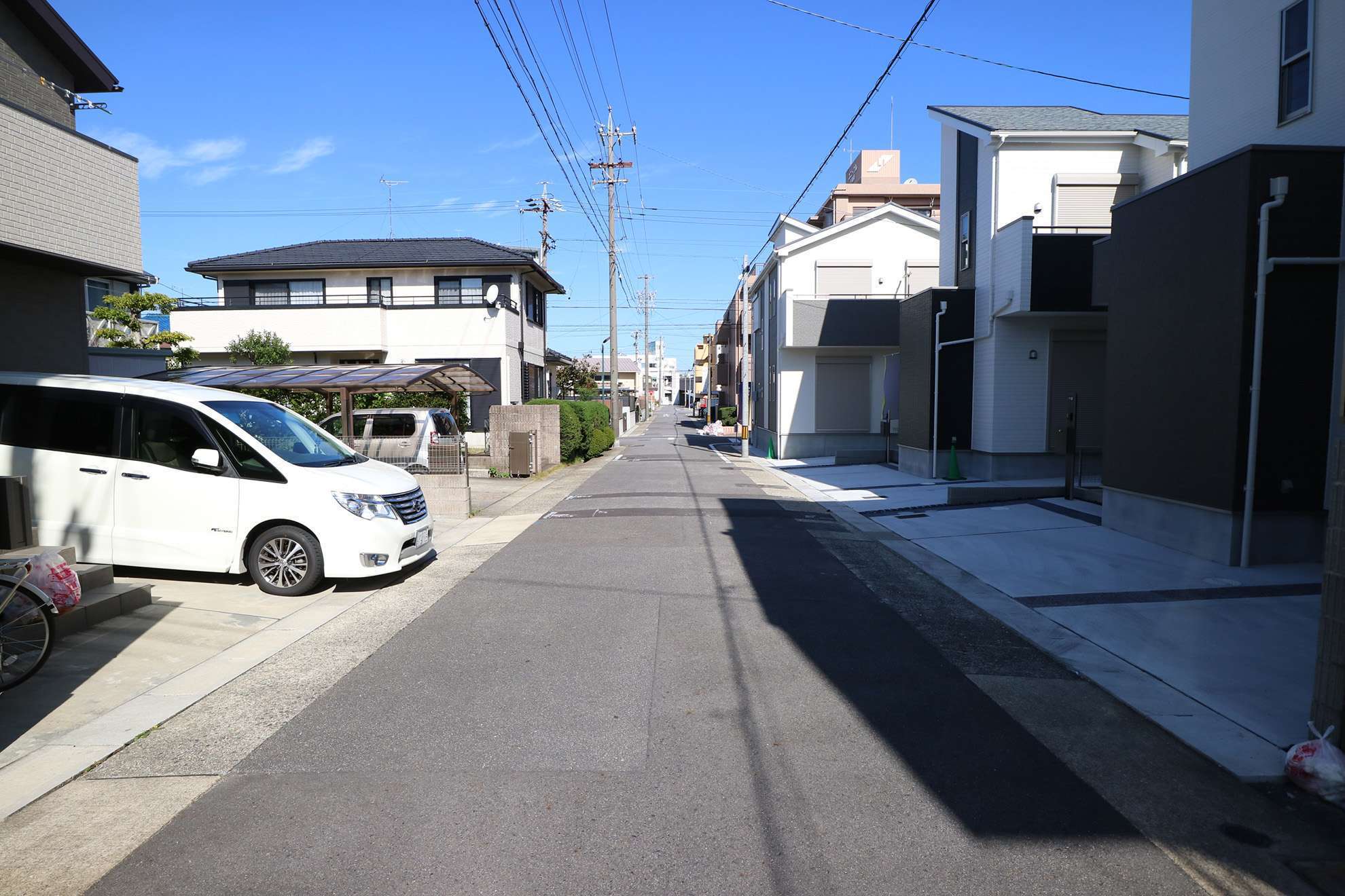 やや狭い通り沿いに、一戸建てやハイツ、小規模なマンションなどが立ち並んでいます。