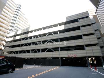 敷地中央にある駐車場棟。屋上には「空の里庭」（屋上庭園・菜園）が設けられています。