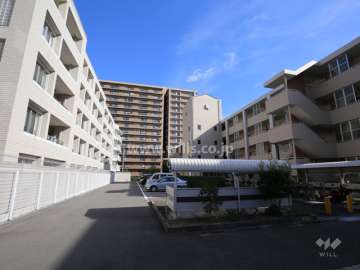 敷地南側はマンション（市営住宅）の駐車場で、建物と間隔があります。