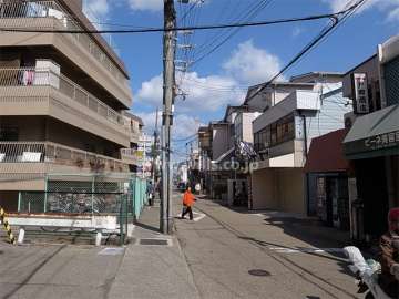 敷地東側の前面道路。商店が立ち並ぶ賑やかな通りです。