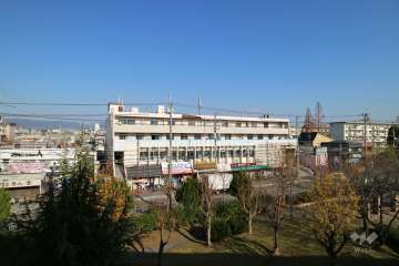 川添デパートマンションの遠景。周辺はマンションと一戸建てなどが混在する静かな住宅地です。