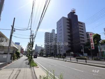 ユニーブル神丘の遠景(北西側から)周辺はマンションと商業ビル等が混在するエリアです。前面道路は片側二車線のバス通りです。