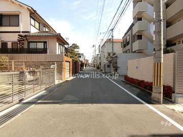 敷地北側の前面道路。周辺はマンションと一戸建てなどが混在する住宅地です。