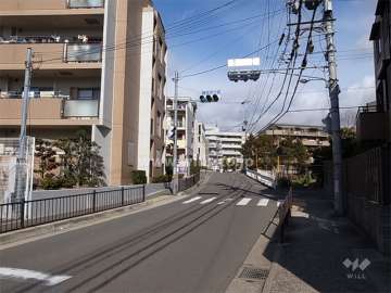敷地東側の前面道路。周辺にはマンションが多く建ち並んでいます。