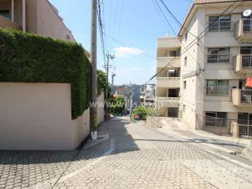 敷地東側の前面道路。坂の上にあるマンションです。