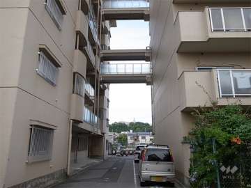 北棟と南棟を結ぶ渡り廊下。その下には来客用駐車場があります。
