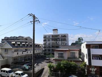 三旺マンション第7上社の遠景。周囲は戸建てやマンションが立ち並ぶ住宅地。敷地南側は駐車場になっています。