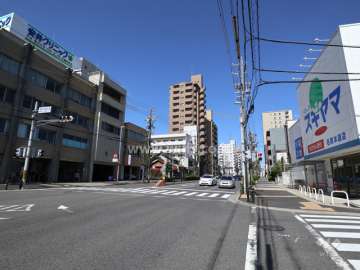 星ヶ丘グランドハイツの遠景(北東側から撮影)※周辺はマンションや店舗が混在しています。前面道路は片側二車線のバス通りです。