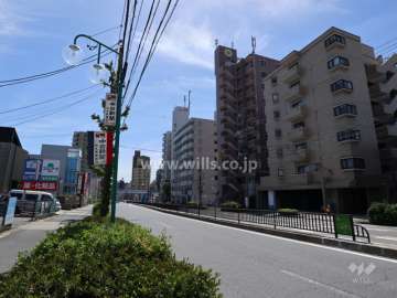 メゾン・ド・エトワールの遠景(北東側から)周辺はマンションと商業ビル等が混在するエリアです。前面道路は片側二車線のバス通りです。