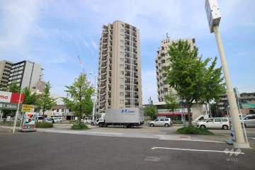 プラウド御器所の遠景。周辺は、住宅の他、店舗や事務所などが混在する街です。