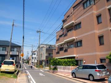 敷地西側の前面道路。一戸建てやマンションが立ち並んでいます。