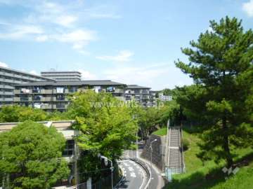 公社山田西Ｂ団地の遠景。木々に囲まれた緑豊かな住環境。