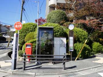目の前にバス停、電話ボックス、ポストがあります。