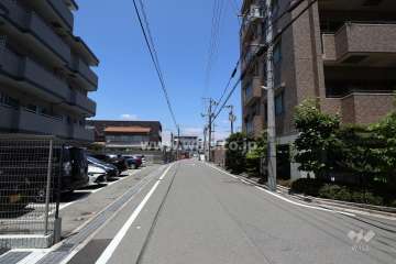 敷地東側の前面道路。周辺は戸建やマンションが立ち並ぶ閑静な住宅街です。