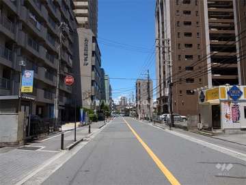 敷地西側の前面道路。周辺は住宅の他、店舗や事務所が立ち並ぶ商業地です。