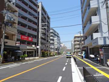 敷地東側の前面道路。周辺には住宅の他、店舗や事務所が建ち並んでいます。