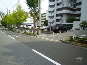 駐車場入り口。敷地北側は街路樹のきれいな二車線のバス通りです。