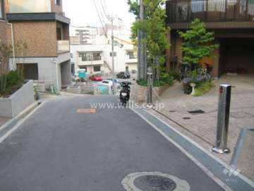敷地北側の前面道路。周辺はマンションと一戸建てが混在する静かな住宅地です。