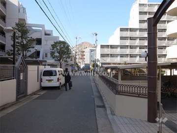 敷地南側の前面道路。周辺はマンションが多く立ち並ぶ住宅地。