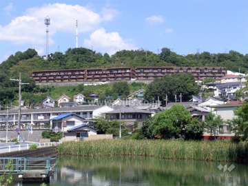 マンション遠景。周囲を木々に囲まれ、緑豊かです。