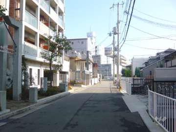周辺はマンションと一戸建てが混在する住宅地。敷地の北側に阪急神戸線、西側に産業道路が走っています。