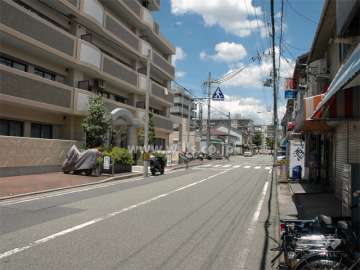 敷地東側の前面道路。通り沿いには店舗が立ち並んでいます。