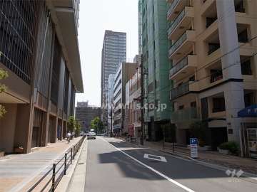 敷地北側の前面道路。周辺は住宅の他、店舗や事務所が並ぶ商業地です。