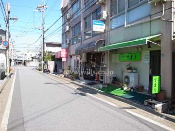 敷地西側の前面道路。建物1階西面は店舗部分になっています。