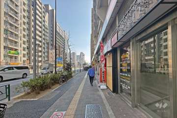 敷地の東側前面道路は都道305号です（北側から）。「大久保通り」バス停がマンションの目の前にあります。