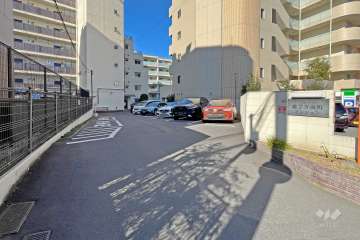 エントランスアプローチ。環七通りに面していますが、前面には駐車場スペースが広く確保され、居住部分は大通りから離れています。