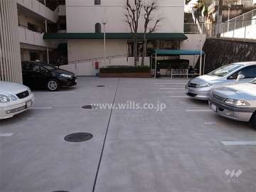 敷地内駐車場（平面式）と駐輪場。正面、奥がエントランスです。