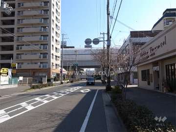 敷地南東側の前面道路。沿道には店舗が立ち並んでいます。
