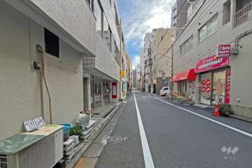 敷地の西側前面道路（北側から）。コインランドリーがあります。