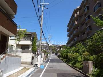 敷地西側の前面道路。周辺はマンションと一戸建てが混在する静かな住宅地です。